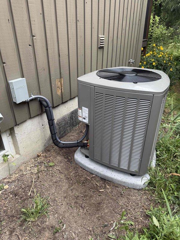 Completed full HVAC system installation including a Lennox 90,000 BTU furnace with humidifier, 3-ton air conditioning condenser unit with right-side configuration, and evaporator coil. Outdoor condenser unit was positioned on concrete pad against building exterior with proper refrigerant line connections and electrical hookup. Indoor furnace was mounted on platform in mechanical room with PVC venting installed vertically through ceiling for intake and exhaust, electrical panel connection completed using flexible conduit, and ductwork integration finalized. All equipment reconnected and system tested for proper operation upon completion.