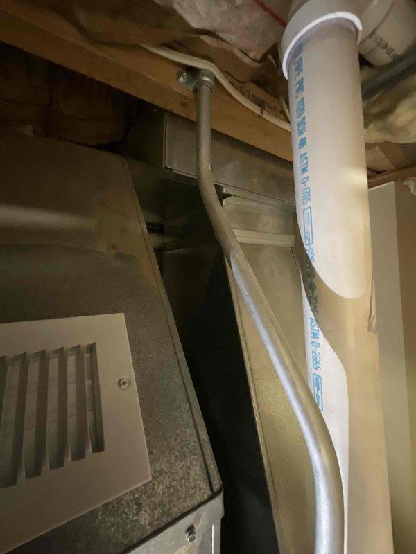 Conducted comprehensive assessment of dual HVAC system installation for residential property with two 16-year-old air conditioning units experiencing complete cooling failure and two gas furnaces of similar age, one non-operational. Following previous diagnostic service call confirming equipment replacement necessity, performed detailed evaluation of existing ductwork infrastructure, including galvanized steel rectangular supply ducts, return air grilles, and PVC condensate drainage systems. Inspected mechanical room installation showing proper integration of sheet metal ductwork with vertical and horizontal runs through floor joists in unfinished basement area. Documented current system configuration including vent locations, drainage piping with visible manufacturer markings, and structural duct mounting between wooden framing members. Prepared full system replacement estimate for dual zone HVAC installation requiring complete removal and replacement of both air conditioning condensi