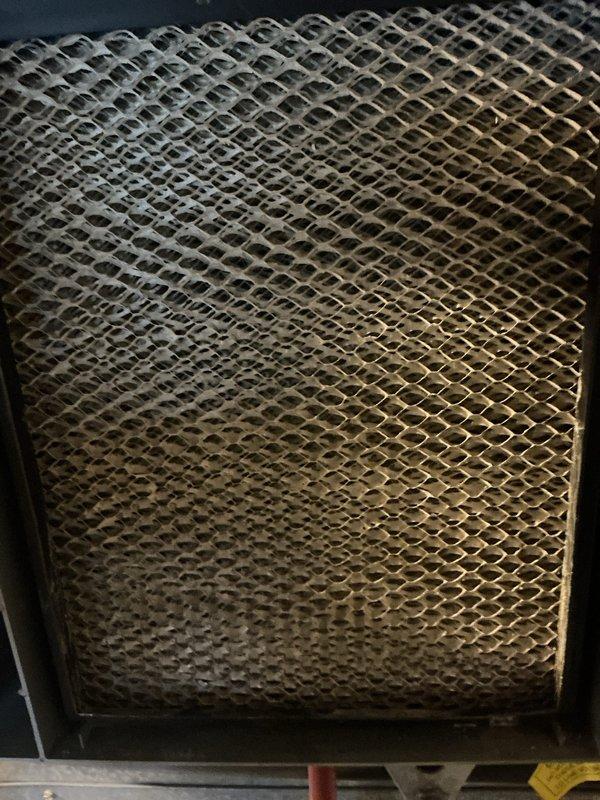 Completed routine furnace maintenance and tune-up on a 5-year-old heating system located in basement. System was found operating properly with thermostat maintaining accurate temperature control at 73 degrees. Inspected evaporative cooler pad which showed moderate accumulation of dust and particulate matter throughout the honeycomb mesh filter material, with heavier buildup concentrated in center sections. All components tested and confirmed functioning within normal parameters.