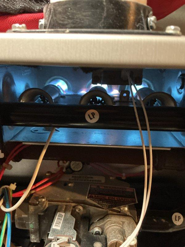 Completed scheduled AHC maintenance on residential HVAC system, including inspection of air handler components and burner assembly. Inspected return air grille, verified proper airflow through ventilation system, examined burner operation with visible flame pattern, and checked gas valve connections and electrical wiring for LP furnace unit.