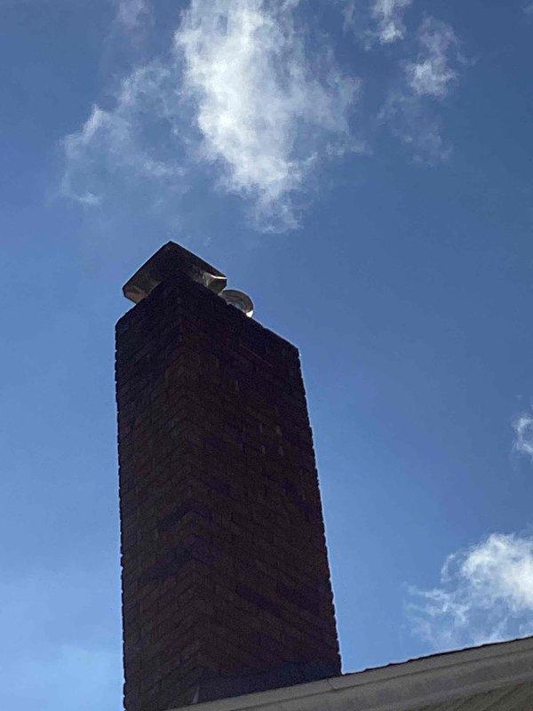 Completed full HVAC system installation including 70,000 BTU furnace with chimney liner, 2-ton air conditioning unit with evaporator coil positioned at rear of system, and dedicated electrical circuit. Obtained mechanical and electrical permits prior to installation, documented completed work with interior equipment photos and exterior chimney cap installation.