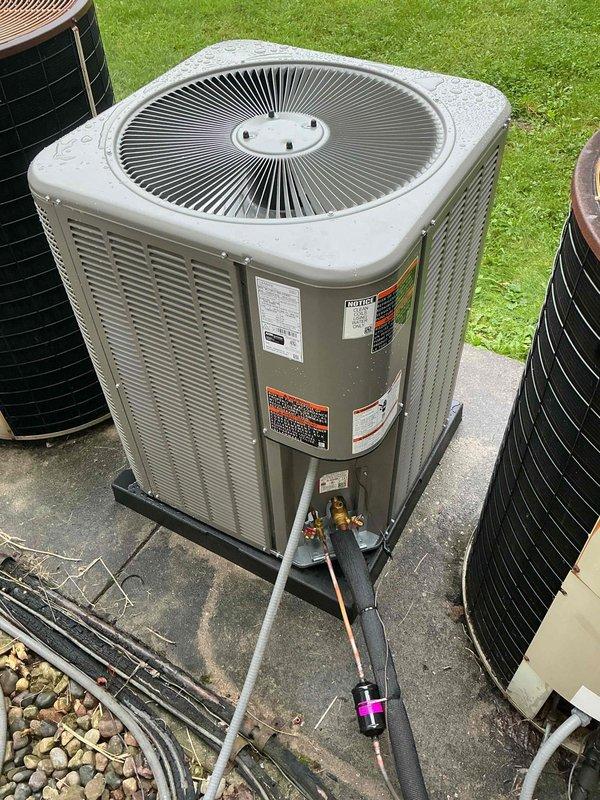 Completed installation of 5-ton air conditioning system including outdoor condenser unit and indoor evaporator coil. Positioned new Lennox condenser on concrete pad with proper base support, connected refrigerant lines with appropriate valve connections, and installed electrical disconnects and junction boxes on exterior wall. System tested and verified operational with all mechanical connections secured per manufacturer specifications.