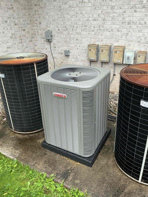 Completed installation of 5-ton air conditioning system including outdoor condenser unit and indoor evaporator coil. Positioned new Lennox condenser on concrete pad with proper base support, connected refrigerant lines with appropriate valve connections, and installed electrical disconnects and junction boxes on exterior wall. System tested and verified operational with all mechanical connections secured per manufacturer specifications.