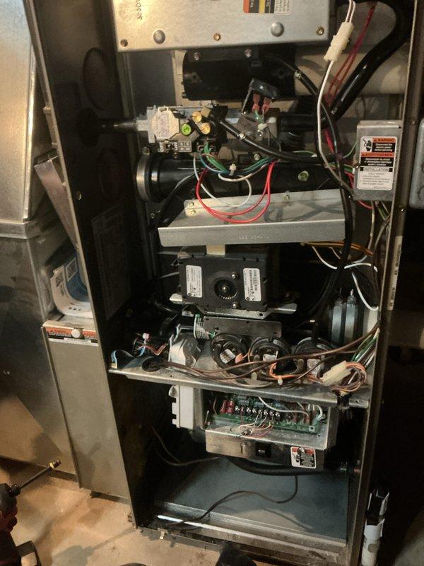 Completed comprehensive furnace cleaning and inspection tune-up on residential heating system. Accessed furnace cabinet, inspected blower motor assembly, electrical connections, control boards, and all internal components. Verified proper operation of all mechanical systems, checked wiring integrity across multiple colored wire connections, and confirmed all safety labels and manufacturer specifications were intact and visible.