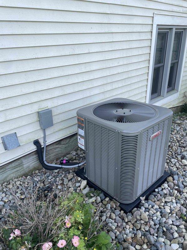 Completed installation of 2.5 ton air conditioning system with matching evaporator coil. Positioned outdoor condensing unit on mounting pad with rock bed in right side yard, installed electrical disconnect and conduit connection to exterior wall. Inside mechanical room, installed new evaporator coil and connected refrigerant lines to existing furnace system, integrated ductwork connections, and completed all electrical wiring. System was charged with refrigerant, tested for proper operation, and all connections verified for secure fit and proper airflow.
