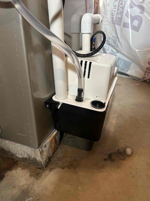 Responded to service call for air conditioning system not cooling due to water leak from cracked condensate leak detector. Upon inspection, found the condensate pump assembly experiencing leakage at the detector connection, causing water damage to surrounding floor area and preventing proper system operation. Replaced faulty leak detector component and condensate pump assembly, reconnected drainage lines with proper PVC fittings, tested system for proper drainage flow, and verified air conditioning unit returned to normal cooling operation with no further leakage detected.