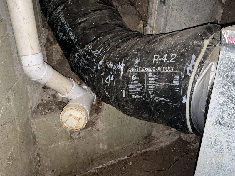 Conducted site assessment for air conditioning replacement estimate at ranch-style residence with basement-located HVAC equipment. Evaluated existing working AC unit and natural gas furnace system, documented electrical service panel rated at 200 amps, inspected flexible ductwork system with R-4.2 insulation rating and associated PVC condensate drainage piping in basement installation area to determine specifications for proposed equipment replacement.