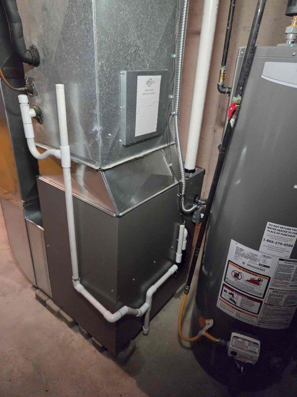 Completed installation of 90,000 BTU furnace unit in basement mechanical room. Installed new furnace with proper venting using white PVC piping, connected galvanized metal supply plenum and ductwork, and established all necessary gas line connections. Reconnected existing electrical service, verified all safety controls, and ensured proper clearances from water heater and surrounding utilities per code requirements.