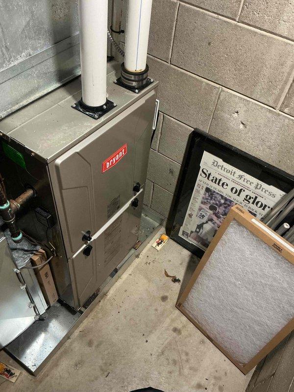 Responded to no heat call on 10-year-old Bryant forced air furnace system. Upon arrival, found unit operational but customer reported excessive noise during operation and confusion regarding cooling versus heating function. Performed system inspection and documented equipment condition with photos showing furnace installation, condensate drainage system with PVC piping, refrigerant lines, and auxiliary components in basement mechanical room. Verified furnace operation, checked condensate drain lines for proper function, and inspected all visible components including air handler connections and ventilation system. Educated customer on proper system operation and differences between heating and cooling modes for forced air system.