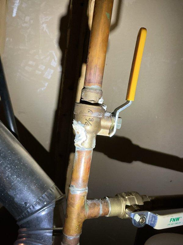 Responded to service call for inspection of traditional gas-fired water heater with reported corrosion on cold water supply line. Upon arrival, conducted thorough visual assessment of water heater and associated plumbing connections. Confirmed presence of moderate surface corrosion and rust deposits at the cold water inlet pipe connection point on top of the unit. Corrosion exhibited characteristic orange-brown oxidation with granular, crusty texture and material flaking around the copper pipe junction. Inspected all threaded brass fittings, ball valve assembly, and pipe connections for integrity and potential leak points. Verified no active water leaks, moisture accumulation, or dripping present at time of inspection. Examined PTFE tape application on threaded connections and confirmed proper sealing. Assessed overall condition of copper supply piping, noting age-related patina and surface discoloration consistent with normal wear. Documented corrosion location and extent through phot