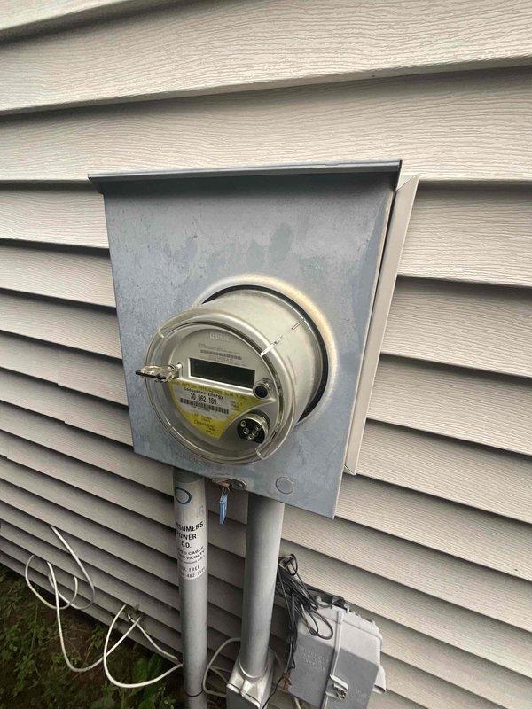 Conducted comprehensive site evaluation for new whole home generator installation at manufactured home residence. Assessed existing electrical service panel, main meter configuration, and available utility connections to determine optimal generator placement and integration requirements. Documented current electrical infrastructure including exterior meter mounting, disconnect box location, and interior utility room layout with water heater and treatment systems to identify proper transfer switch positioning and fuel line routing for Kohler generator system installation.