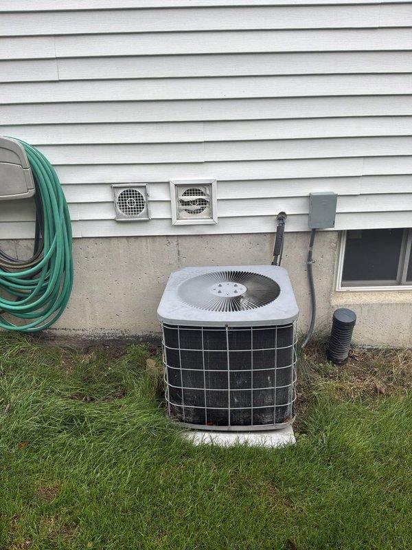 Conducted comprehensive evaluation of 22-year-old residential HVAC system for full replacement estimate. Assessed existing furnace installation in mechanical room, including extensive galvanized ductwork system, vertical cylindrical water heater integration, and copper piping configuration throughout basement utility space. Inspected exterior air conditioning condenser unit positioned on concrete pad, evaluating wire mesh protective housing, foundation ventilation components, and drainage systems. Documented all equipment specifications, ductwork layout, and mechanical connections through photographic records to provide accurate replacement system recommendations for aging equipment approaching end of service life.
