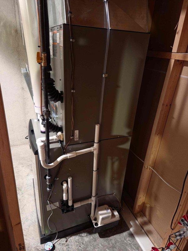 Completed full HVAC system installation including 70,000 BTU furnace, 3-ton air conditioning condenser unit, and evaporator coil. Installed Lennox brand condenser unit in rear yard with proper placement on foundation pad adjacent to residential structure. Mounted air handler unit vertically in basement utility area with secure attachment to interior wall framing. Ran refrigerant lines with proper insulation from outdoor condenser to indoor coil assembly. Installed white PVC condensate drain line with appropriate slope and trap configuration, including condensate pump for proper drainage. Connected all electrical components per code requirements. Verified all mechanical and electrical connections for proper operation. System tested and confirmed operational upon completion of installation.