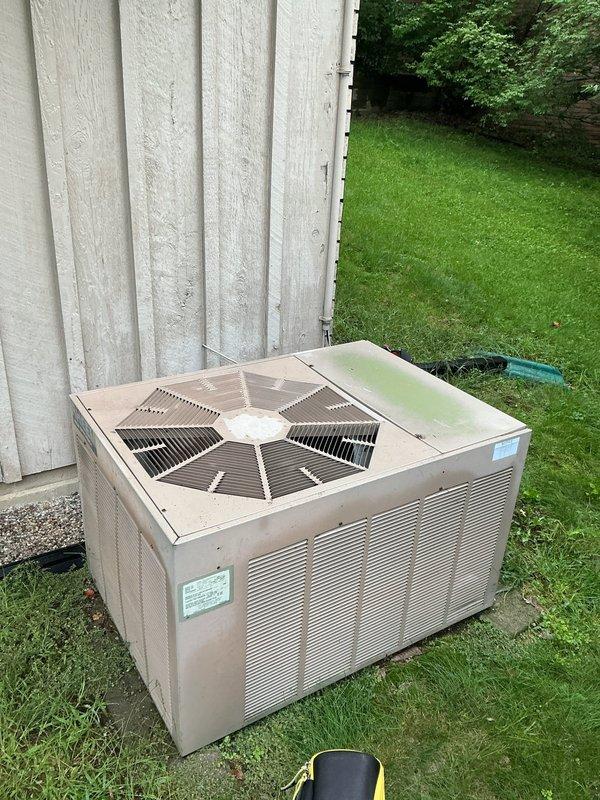 Performed comprehensive AC tune-up on residential split system with outdoor condenser unit and Carrier indoor air handler/furnace combination. Inspected outdoor condenser unit showing age-related weathering and dirt accumulation; cleaned unit exterior and verified fan operation through protective guard. Evaluated indoor evaporator coil mounted above furnace, noting visible condensation indicating active cooling cycle. Checked refrigerant levels and system pressures to determine if refrigerant charge was adequate; found system operating within manufacturer specifications with no refrigerant leak detected or addition required. Verified proper condensate drainage through PVC drain lines, inspected electrical connections, and confirmed system cycling properly. All components functioning as designed with no immediate service needs identified beyond routine maintenance completed.