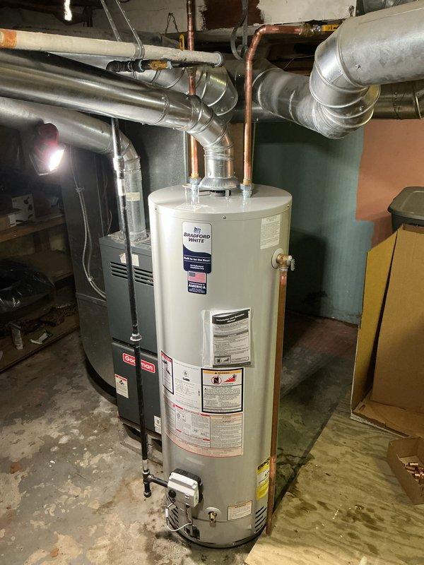 Successfully installed a new 40-gallon tanked water heater (model RG240T6N) in the basement utility area. The installation included proper connections to existing copper supply lines with brass fittings, integration with the HVAC ductwork system, and all necessary plumbing connections to ensure optimal performance and code compliance.