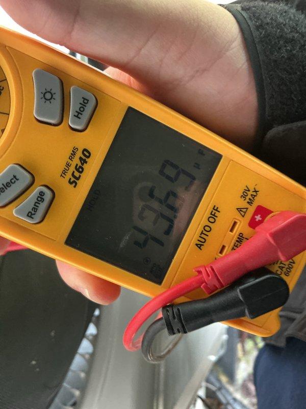 Performed scheduled preventive maintenance on outdoor air conditioning condenser unit. Cleaned heavily soiled front panel and coil surfaces, removing significant accumulation of dirt, debris, and organic matter that had restricted airflow. Verified system operation with digital multimeter, recording temperature reading of 93°F. Removed vegetation and debris from base of unit to ensure proper drainage and airflow clearance around equipment.