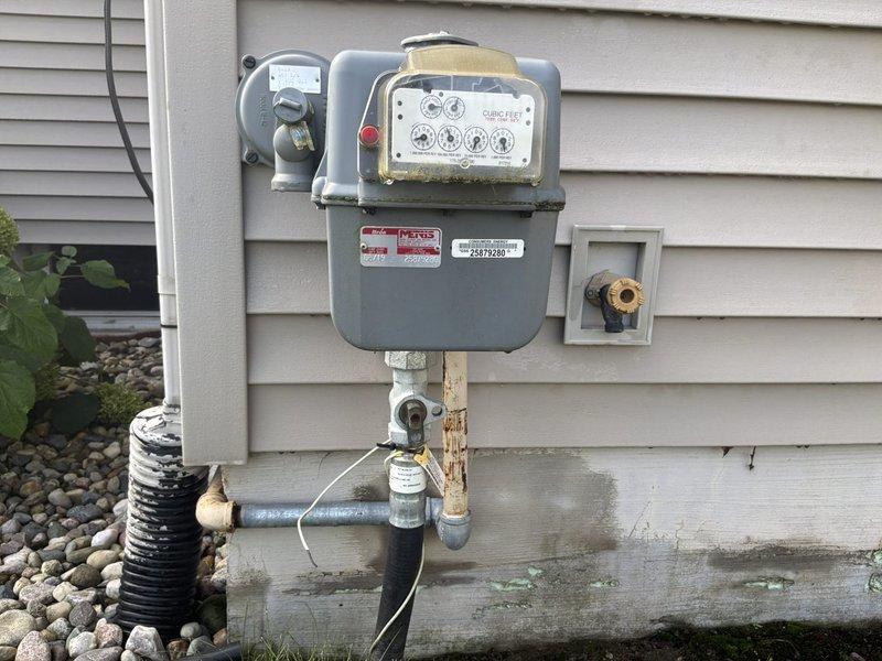 Conducted on-site evaluation for whole-house Kohler generator installation at residential single-family home. Assessed existing electrical service panel location in basement utility area and documented gas meter configuration on exterior wall to determine optimal generator placement and required electrical connections. Photographed current electrical infrastructure and gas service equipment to develop comprehensive installation estimate including transfer switch placement, load calculations, and utility coordination requirements.