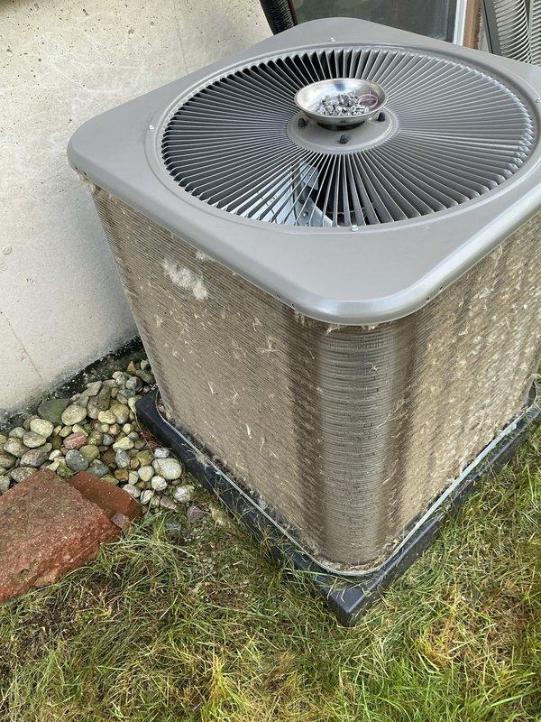 Completed comprehensive ComfortGuard maintenance service on residential HVAC system operating under 5-year warranty plan. Performed full tune-up on air conditioning condenser unit and furnace system, both confirmed in proper working condition. Outdoor condenser unit showed significant accumulation of dirt, dust, and debris on condenser fins and coils, which was thoroughly cleaned to restore optimal airflow and heat transfer efficiency. Inspected fan motor assembly, grille, and mounting pad for proper operation and stability. Verified refrigerant levels, electrical connections, and overall system performance. All components tested and functioning within normal parameters upon service completion.