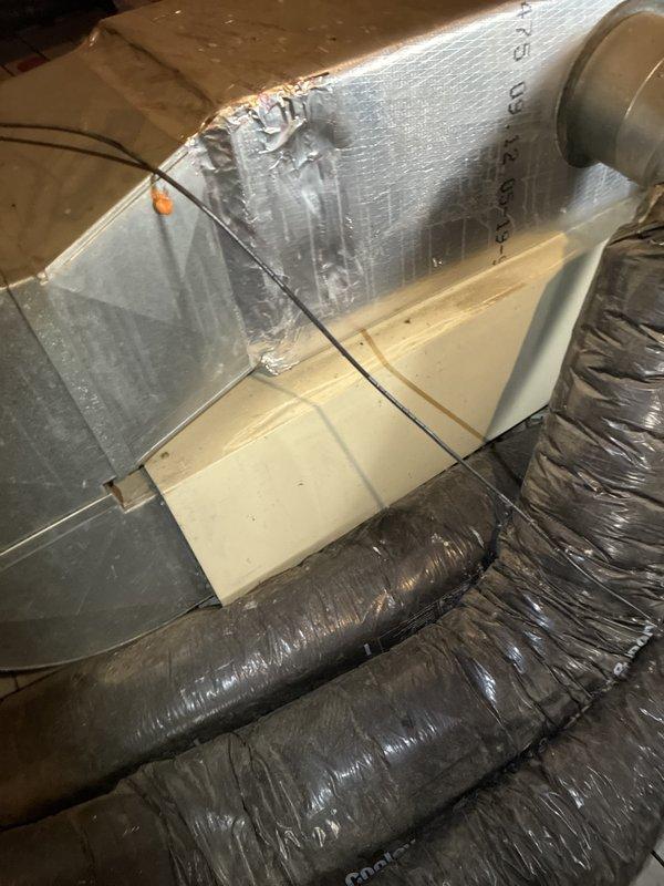 Provided estimate for replacement of 27-year-old non-operational air conditioning system with attic-mounted air handler and outdoor condenser unit. Assessed existing ductwork configuration including flexible ducts and main supply plenum in attic space, as well as exterior condenser location against brick wall with existing refrigerant line set and electrical disconnect. Reviewed natural gas furnace compatibility and discussed complete system replacement options with homeowner.