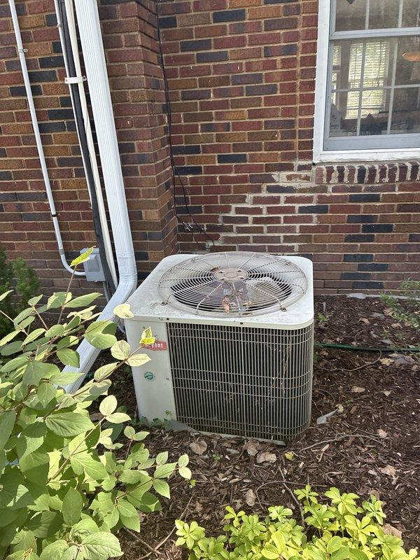 Provided estimate for replacement of 27-year-old non-operational air conditioning system with attic-mounted air handler and outdoor condenser unit. Assessed existing ductwork configuration including flexible ducts and main supply plenum in attic space, as well as exterior condenser location against brick wall with existing refrigerant line set and electrical disconnect. Reviewed natural gas furnace compatibility and discussed complete system replacement options with homeowner.