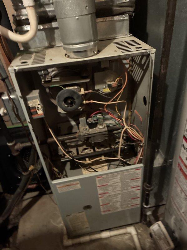 Provided comprehensive estimate for complete HVAC system replacement including natural gas furnace and air conditioning unit located in basement. Existing 20+ year old equipment is non-operational with visible wear on internal components including blower motor, wiring, and control boards. Significant condensation observed on ductwork indicating potential efficiency and humidity control issues requiring attention during replacement installation.