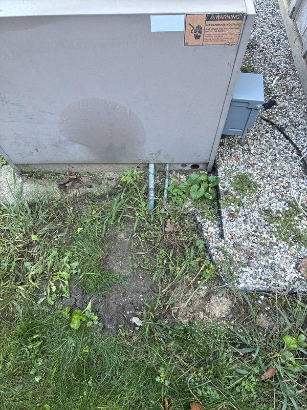 Responded to residential air conditioning service call for system evaluation and potential refrigerant concerns. Performed comprehensive assessment of outdoor condensing unit and indoor air handling components, documenting equipment condition through photographic documentation. Upon inspection, outdoor unit showed signs of age with weathered concrete pad and vegetation encroachment around base, while indoor ductwork and refrigerant lines displayed normal operational characteristics with proper mounting and connections intact.