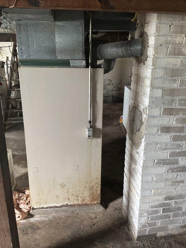 Responded to service call for furnace that would not turn off, affecting whole house heating system. Upon arrival, assessed 46-year-old furnace unit from the 1980s located in basement utility area. Issue began after heat was activated following chimney obstruction from bats. Per customer request, shut off heat to system. Documented existing equipment condition and provided estimate for complete furnace replacement due to age and obsolescence of current unit.