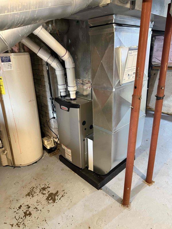 Completed installation of 70,000 BTU furnace in basement utility area with proper reconnection to existing ductwork system. Installed white PVC venting through exterior wall with appropriate termination and support. Obtained mechanical permit prior to installation and verified all connections meet code requirements for safe operation.