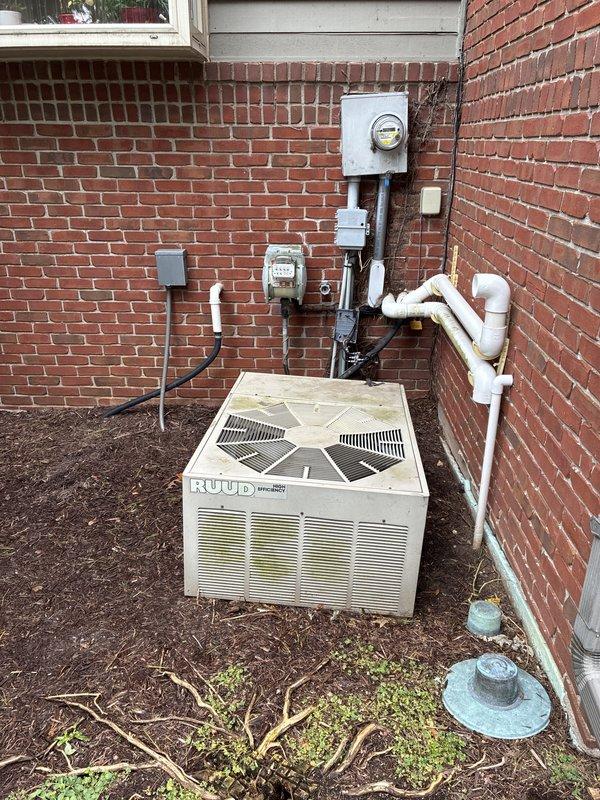 Conducted comprehensive assessment of non-operational 14-year-old RUUD Weather King outdoor condensing unit for complete system replacement estimate. Evaluated existing exterior unit placement, electrical service connections including meter configuration and grounding, condensate drainage routing via PVC piping, and associated indoor mechanical components including basement ductwork, refrigerant line sets, and HVAC infrastructure. Documented current system configuration through photographic records to provide accurate replacement specifications and equipment sizing recommendations for aged air conditioning system.