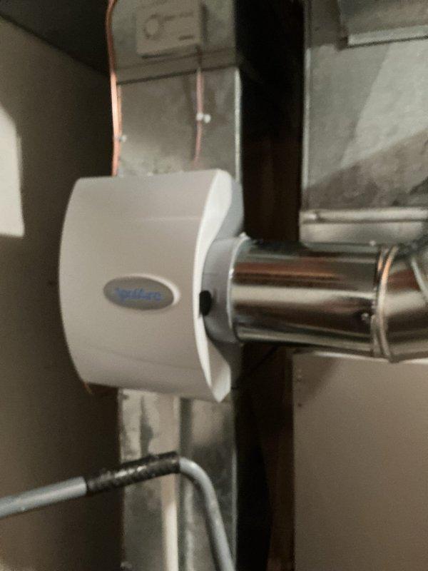 Completed installation of AprilAire M600 whole-home humidifier with connection to existing ductwork and water supply line. Performed annual heating and cooling maintenance on HVAC system, including inspection of outdoor condensing unit positioned beneath deck structure. Conducted water heater maintenance service to ensure proper operation and safety of all equipment.