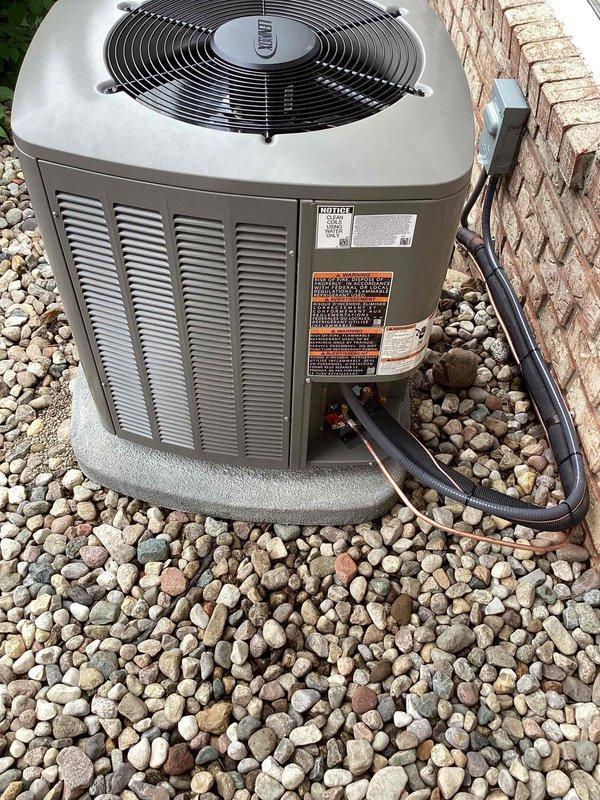 Completed full HVAC system installation including a 70,000 BTU gas furnace with front-access configuration, 2-ton air conditioning condenser unit, and matching evaporator coil. The outdoor condenser was positioned on a composite pad with proper clearances against the brick exterior, refrigerant lines were insulated and routed through the wall penetration, and electrical disconnect was verified. All equipment was reconnected to existing utilities, system was tested for proper operation, and mechanical permit documentation was processed.