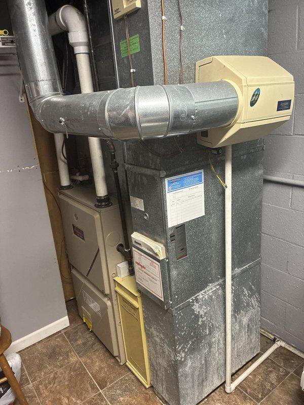 Conducted estimate for replacement of 21-year-old furnace and 26-year-old air conditioning system currently located in basement. Existing equipment remains operational but has reached end of expected service life. Documented current installation configuration including ductwork connections, humidifier integration, and noted significant ice buildup on evaporator coil indicating potential refrigerant or airflow issues that warrant complete system replacement.