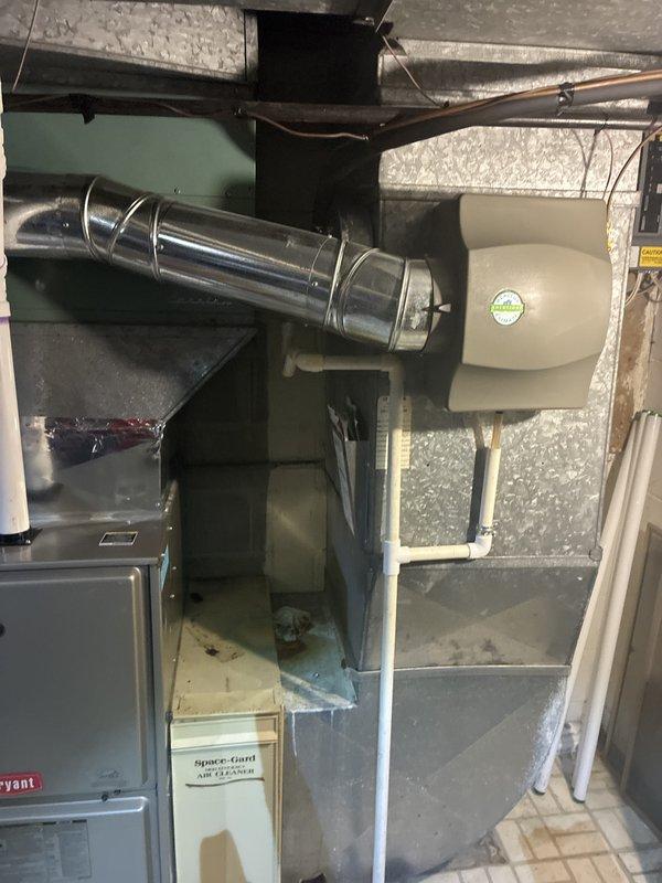 Responded to service call for air conditioning system not blowing cold air. Upon arrival, evaluated 15-year-old HVAC system consisting of Bryant furnace and air handler unit with associated ductwork in basement mechanical room. Conducted comprehensive assessment of existing equipment including inspection of furnace cabinet, ductwork connections, electrical components, and overall system configuration. Documented current installation with photos showing green air handler unit, metallic cylindrical components, gray furnace unit with silver ductwork transitions, and electrical panel. Based on age and condition of equipment, provided estimate for complete HVAC system replacement. Customer placed on priority waitlist for earlier installation availability and received service credit toward future replacement work.