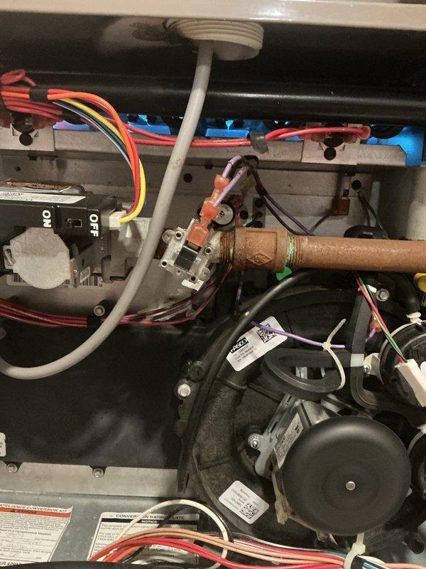 Completed scheduled heating maintenance on York HVAC system. Inspected thermostat operation showing 70°F current temperature with cooling setpoint at 72°F, verified proper display function and control responsiveness. Accessed and inspected internal components including gas valve assembly, ignition system, burner assembly with copper connections, blower motor, and all associated wiring and electrical connections; confirmed all components properly secured and functioning within normal parameters.