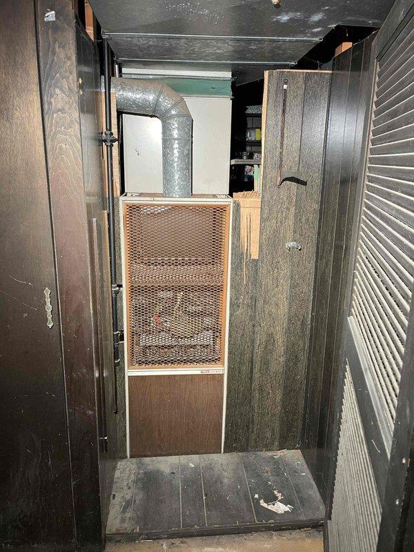 Conducted comprehensive assessment of 51-year-old furnace located in basement utility area accessed via side door. Unit currently operational but has significantly exceeded expected service life. Evaluated existing installation including ductwork configuration, electrical connections, and spatial constraints within confined mechanical room with wood-paneled walls. Documented equipment condition, venting system, and clearance requirements. Prepared replacement estimate for new furnace system accounting for existing infrastructure and access considerations through basement installation.