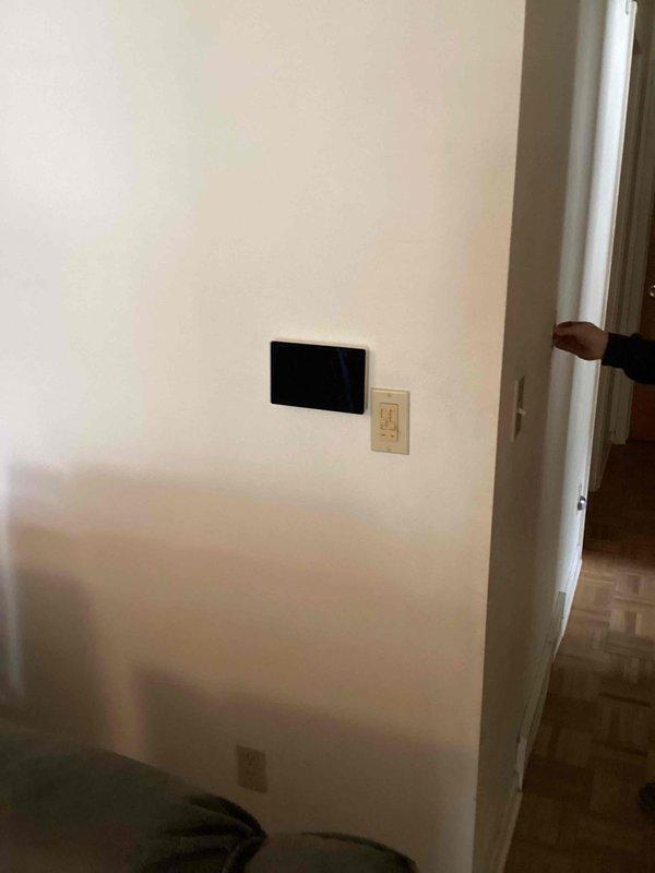 Installed and configured new digital thermostat on interior wall as part of complete HVAC system replacement including 70,000 BTU furnace, 2-ton air conditioning unit, chimney liner, and humidifier. Mounted thermostat adjacent to existing light switch controls and verified proper system communication and operation. Unit tested successfully with all heating and cooling functions responding appropriately.