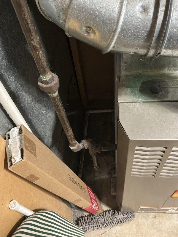 Conducted comprehensive full system estimate for replacement of 16-year-old furnace and air conditioning system in residential property. Inspected existing HVAC equipment located in basement utility area, including aging furnace with beige metal housing and associated ductwork showing signs of wear. Evaluated galvanized metal ductwork, copper piping with visible oxidation, and overall system configuration to determine replacement requirements. Documented equipment condition through photographs and provided recommendations for complete furnace and air conditioner replacement to address immediate customer need for system upgrade.