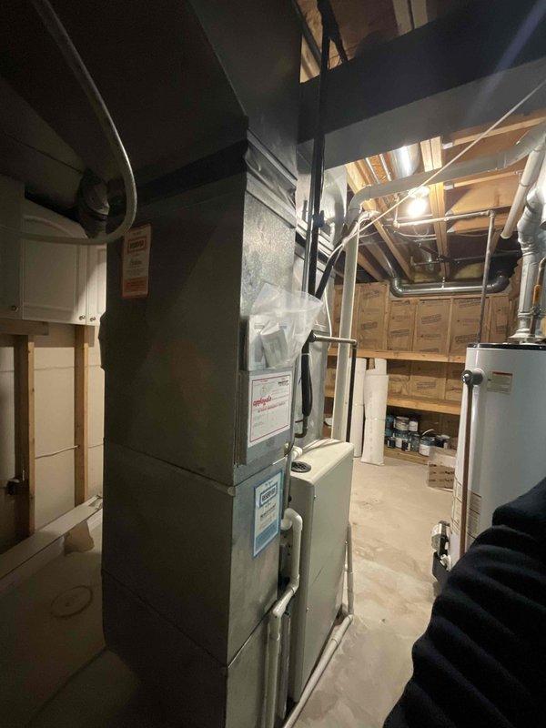 Conducted on-site evaluation for complete HVAC system replacement at residential property. Assessed existing furnace/air handler unit located in basement utility area and outdoor condensing unit positioned on concrete pad with rock landscaping. Documented current equipment condition, utility connections including electrical conduit, disconnect box, refrigerant lines, and PVC drainage, and ductwork configuration with exposed metal distribution system throughout basement space. Provided comprehensive replacement estimate for immediate system upgrade based on customer's request for prompt installation.