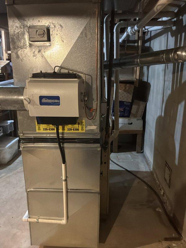 Conducted comprehensive assessment of 25-year-old gas furnace system located in basement mechanical room. Evaluated existing HVAC equipment including furnace unit, air handler, ductwork distribution network, and associated piping infrastructure. Documented current system configuration with detailed photography showing beige furnace unit with manufacturer specifications, metal supply and return ductwork, copper refrigerant lines, and concrete block wall mounting. Assessed condition of horizontal and vertical duct runs, insulated supply plenum, and electrical connections. Provided replacement recommendations and equipment options suitable for residential heating requirements.