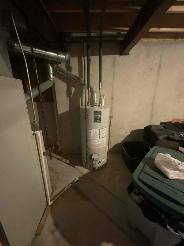 Provided comprehensive estimate for complete HVAC system replacement in basement location, including both furnace and air conditioning unit. Current 30-year-old equipment remains operational but has reached end of expected service life. Assessed existing gray metal furnace with overhead ductwork configuration and evaluated spatial requirements for new equipment installation alongside water heater in utility room with concrete block walls and exposed ceiling joists.