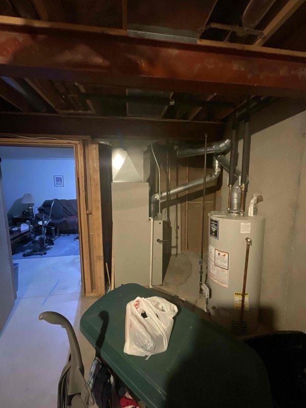 Provided comprehensive estimate for complete HVAC system replacement in basement location, including both furnace and air conditioning unit. Current 30-year-old equipment remains operational but has reached end of expected service life. Assessed existing gray metal furnace with overhead ductwork configuration and evaluated spatial requirements for new equipment installation alongside water heater in utility room with concrete block walls and exposed ceiling joists.