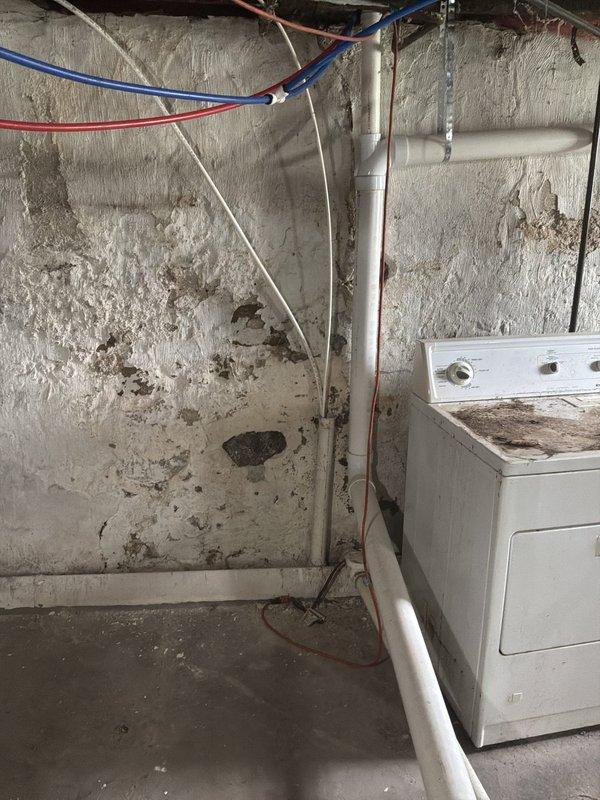 Conducted on-site estimate for mini split installation at newly acquired residential property with no existing HVAC system. Evaluated main living area with hardwood flooring and assessed basement utility space for potential outdoor condenser placement and line routing. Documented room dimensions, electrical access points near utility area with existing dryer connection, and exterior wall penetration requirements for refrigerant lines and condensate drainage.