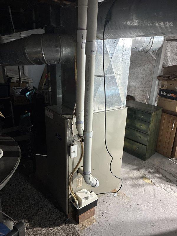 Provided comprehensive estimate for complete HVAC system replacement in basement location, including both furnace and air conditioning units under buy-one-get-one promotion. Existing 30-year-old furnace remains operational, though no air conditioning system currently installed. Assessment included evaluation of existing ductwork configuration with metal supply plenum and rectangular trunk lines, PVC condensate drainage system, and available electrical service. Documented basement installation area with adequate clearance for new equipment placement and confirmed compatibility with existing infrastructure including exposed floor joists and concrete flooring suitable for new unit positioning.