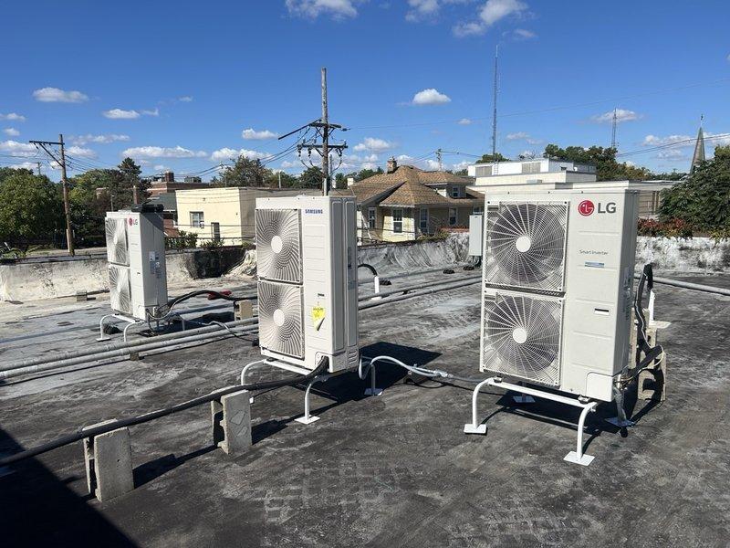 Responded to service call for LG mini split heat pump system (model KUMA4481A) displaying error code 228 indicating refrigerant leak malfunction. Accessed rooftop installation where multiple outdoor condenser units are mounted on elevated frame supports. Performed diagnostic evaluation of the affected LG unit, documented equipment nameplate data showing A2L refrigerant type, and captured photographic evidence of the installation and equipment condition for further assessment and repair recommendations.
