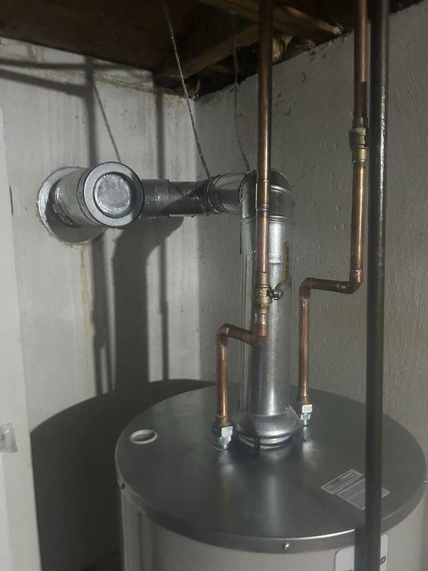 Completed installation of RG250S6N tanked water heater in basement utility area. Established all copper water supply line connections with brass fittings, installed temperature and pressure relief valve, and configured proper metallic venting with flue pipe and elbow joint for exhaust. All mechanical and electrical connections completed per code requirements, with necessary permits obtained for hot water heater replacement.