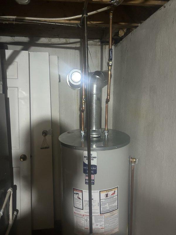 Completed installation of RG250S6N tanked water heater in basement utility area. Established all copper water supply line connections with brass fittings, installed temperature and pressure relief valve, and configured proper metallic venting with flue pipe and elbow joint for exhaust. All mechanical and electrical connections completed per code requirements, with necessary permits obtained for hot water heater replacement.