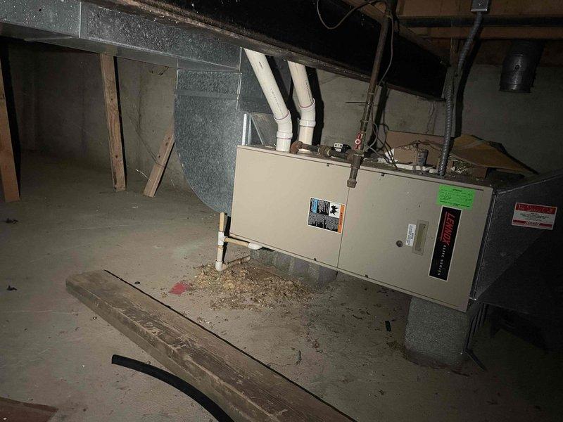 Assessed 30+ year old furnace in basement of 2-story, 2400 sq ft home that had failed and was no longer operational. Evaluated existing dual-furnace system configuration and investigated feasibility of replacing both units with a single high-capacity system to serve entire home. Documented existing equipment location in half basement with poured foundation, photographed current furnace installation and ductwork layout, and provided replacement options and recommendations based on home size and heating requirements.