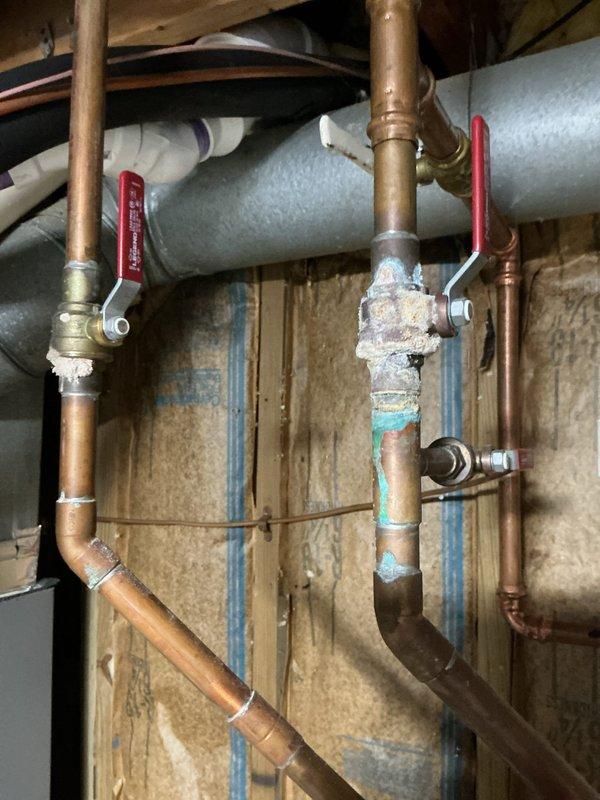 # HVAC Maintenance - ComfortGuard Maintenance Package

Completed comprehensive 5-year recurring maintenance visit on residential HVAC system. Conducted thorough inspection of mechanical systems and associated plumbing components in basement utility area.

## Work Performed

Performed detailed visual inspection of water heater and connected plumbing infrastructure. Documented extensive corrosion on water heater pipe connection at tank entry point, showing significant rust deterioration, pitting, and oxidized material buildup at junction. Noted severely corroded condition requiring immediate attention to prevent potential failure.

Inspected copper supply line network including multiple vertical and horizontal runs with brass fittings and ball valves. Evaluated condition of various pipe sections, noting age variations and patina development. Identified section of copper piping with turquoise corrosion and white mineral deposit accumulation indicating active deterioration process.

Examin