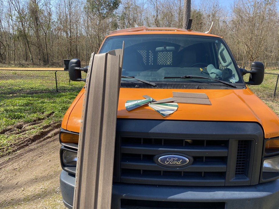 ProTek construction project managers working on finding a matching siding color to repair a house damage by tree strike out along the Alabama River