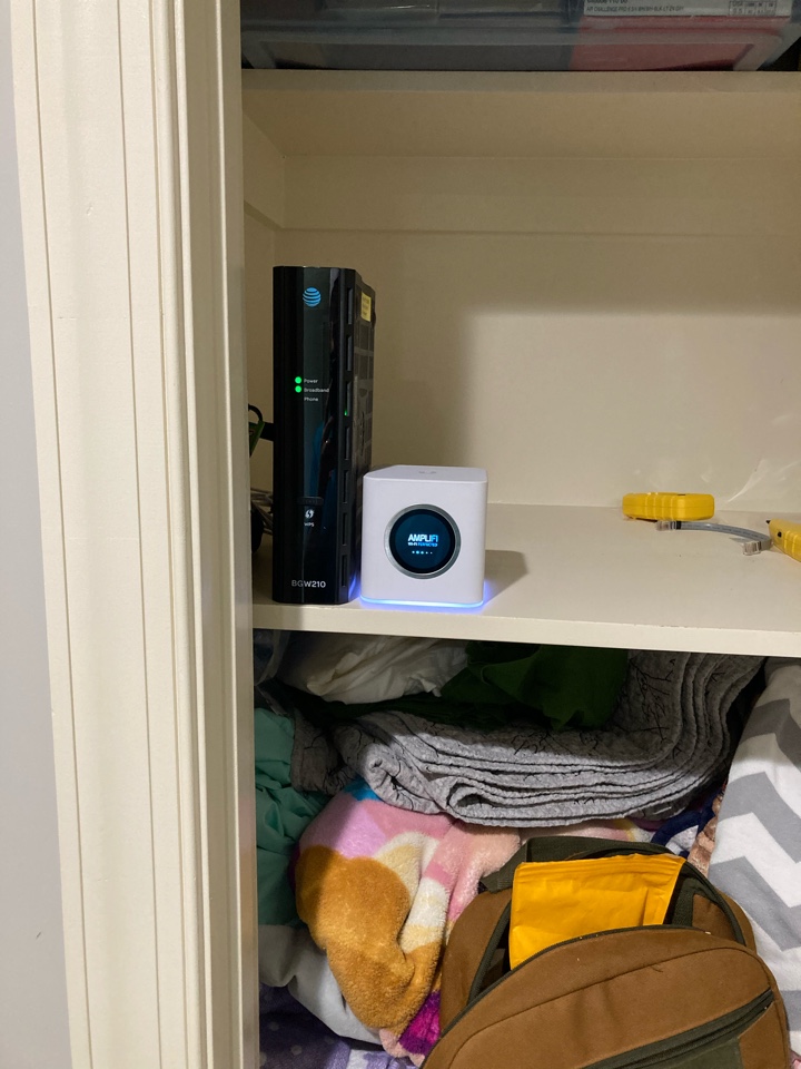 Electrician moving internet modem and setting up WiFi hub in a home